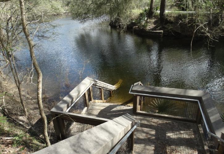 A set of stairs extends down into a dark spring